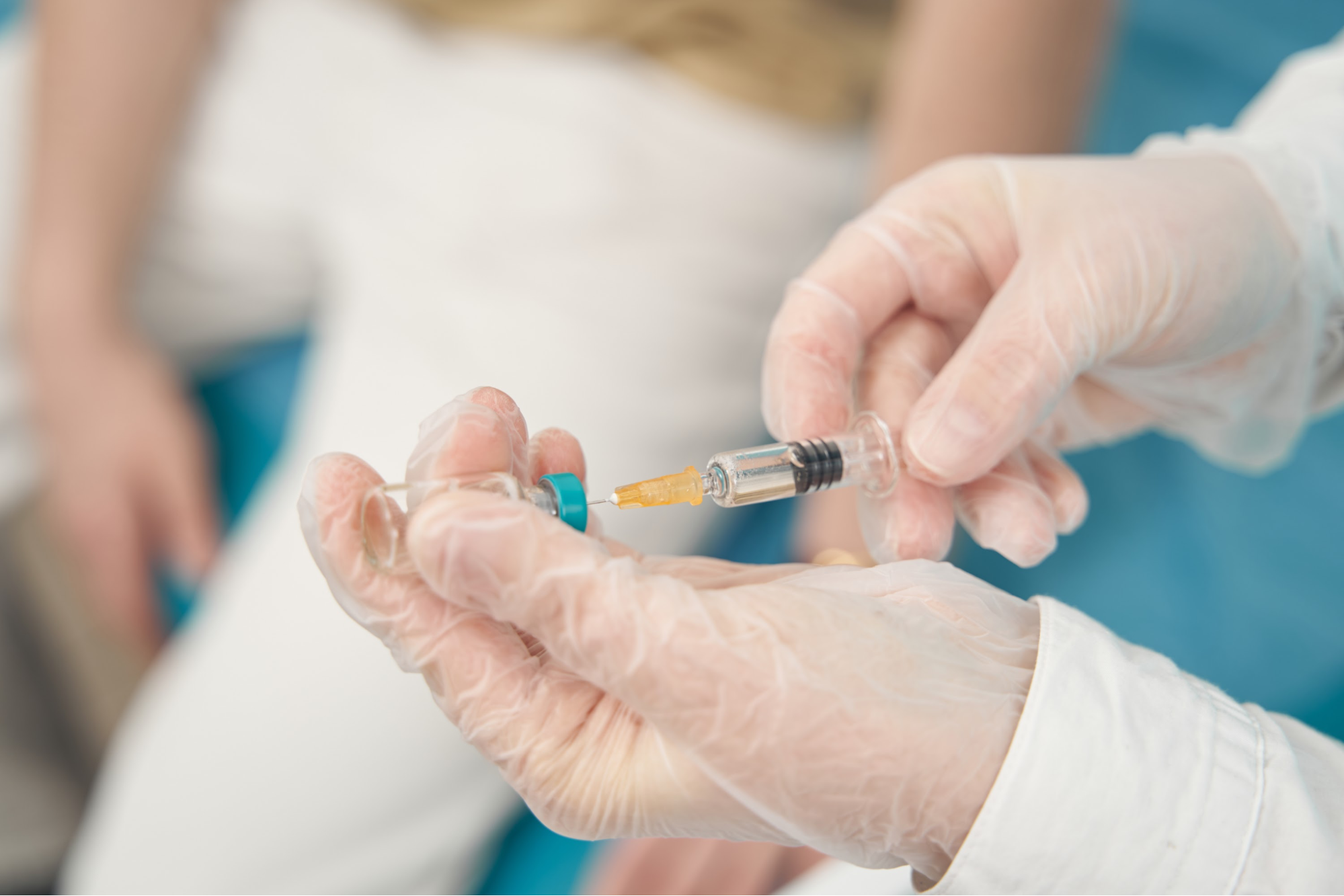 Gloved hands preparing an injection