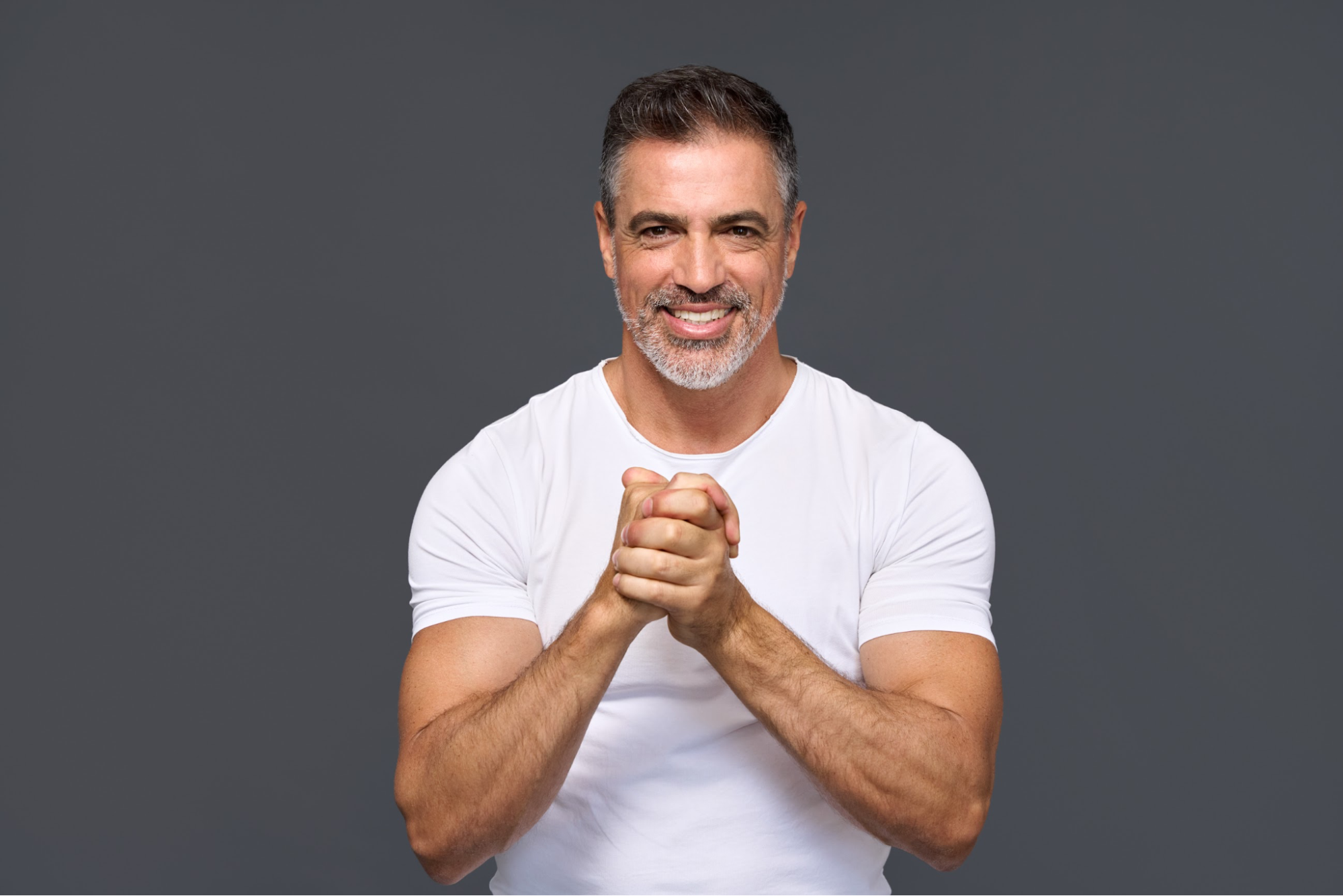 A muscular man in a white shirt smiling