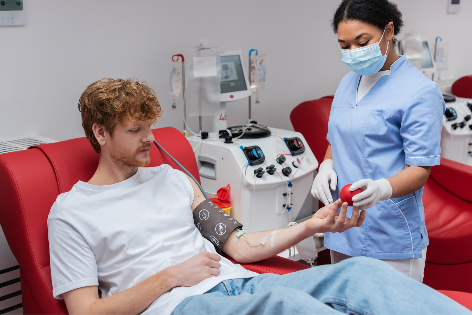 A man being given a stress ball as he’s receiving an IV treatment.