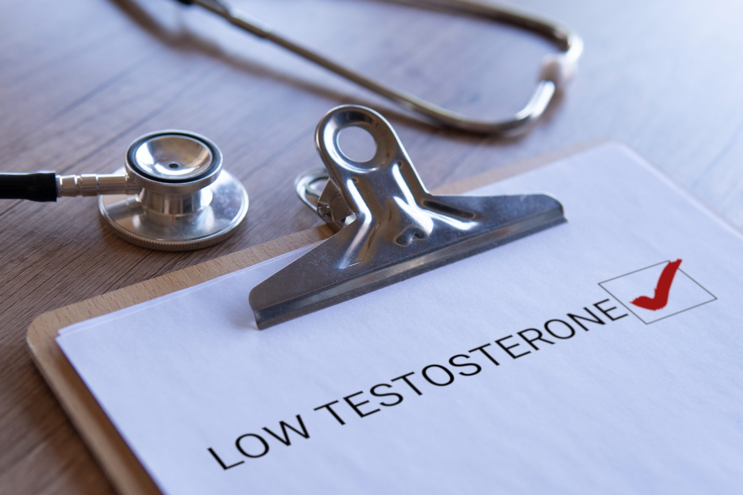 Closeup on a clipboard with a paper indicating a low testosterone diagnosis.