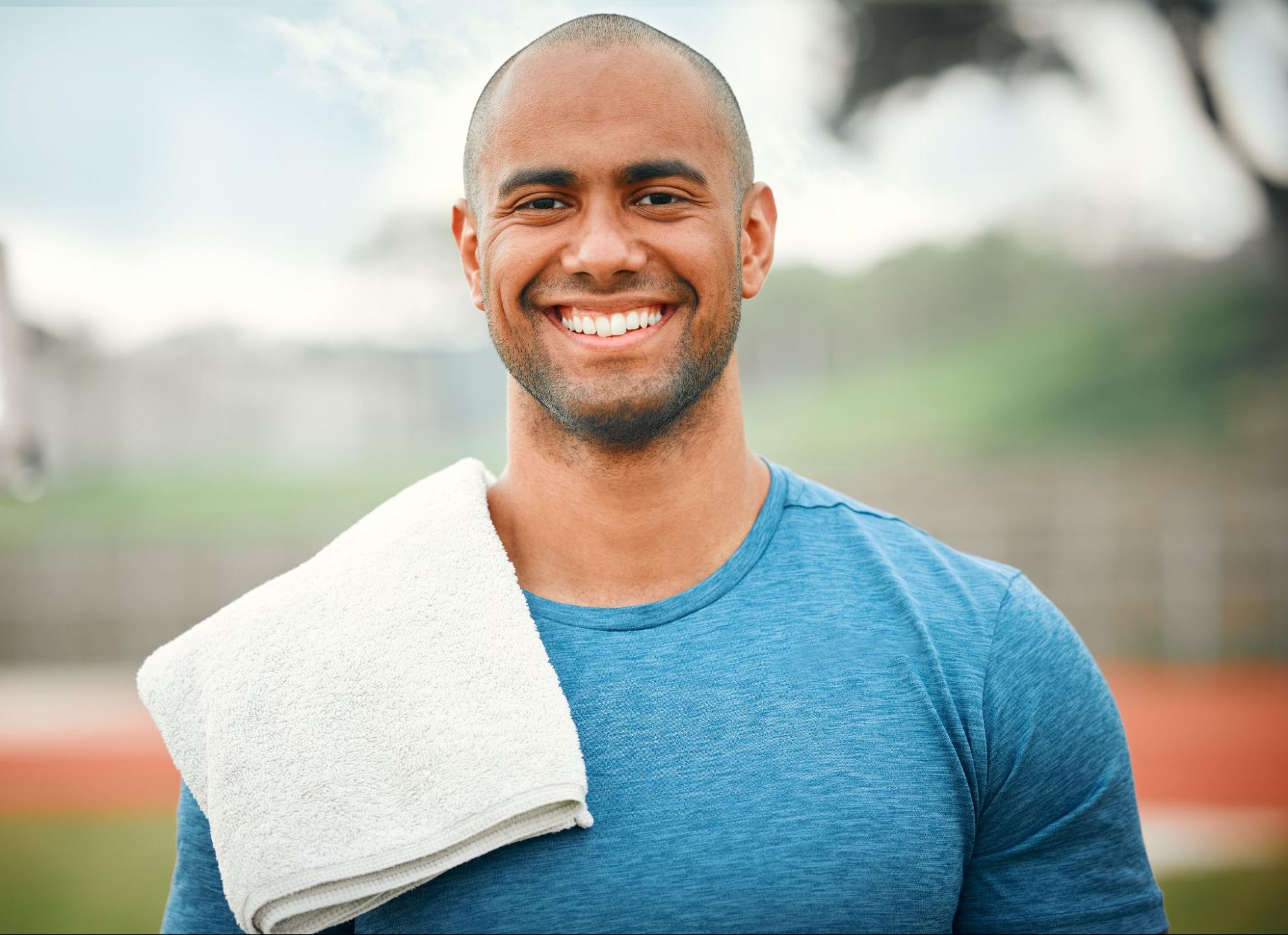 A healthy male athlete with a towel over his shoulder.