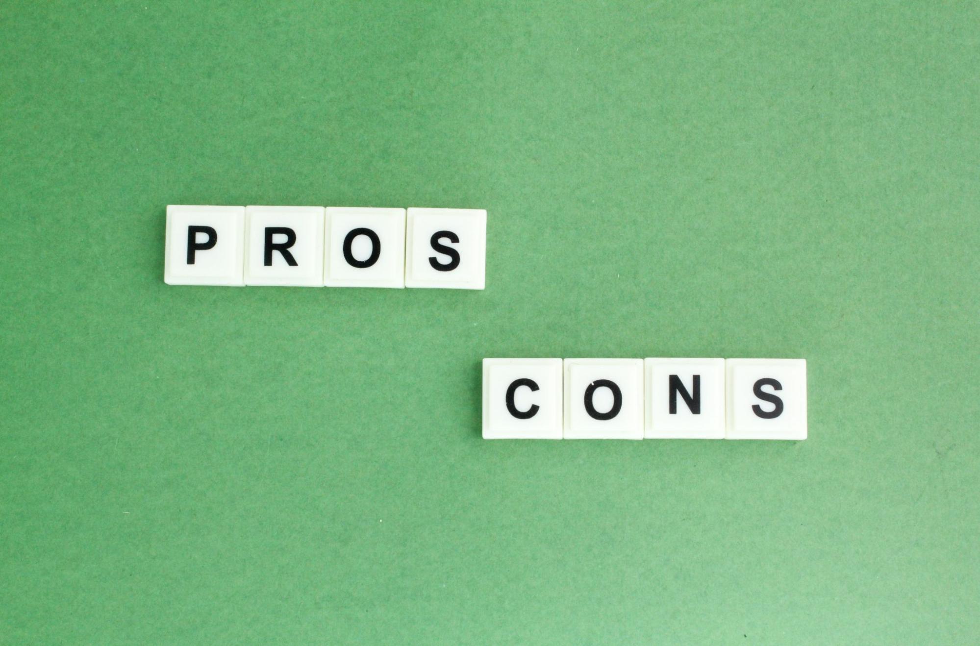 White letter tiles form the words “Pros and Cons” on a green surface